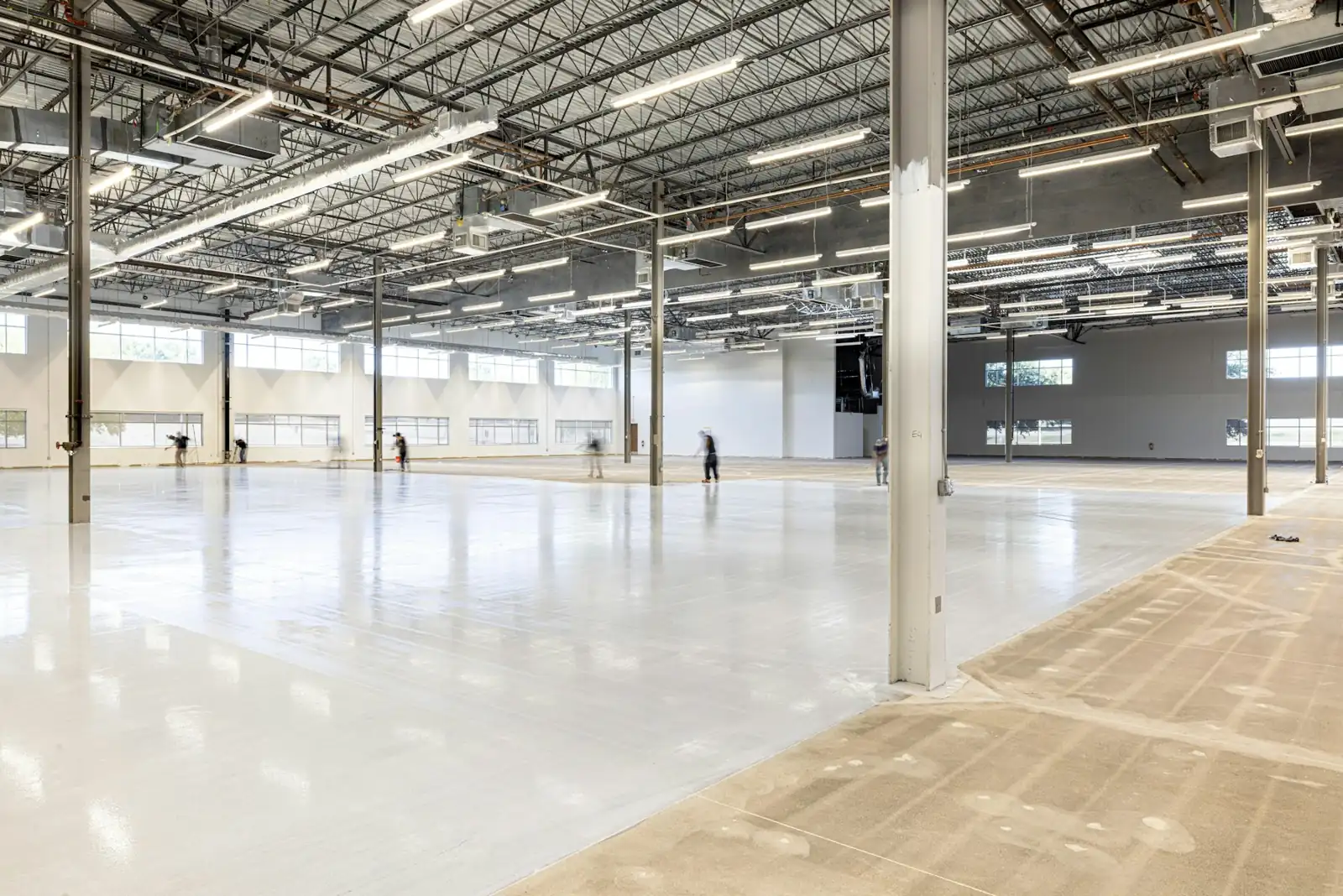 Wide open warehouse with a freshly coated light gray concrete floor